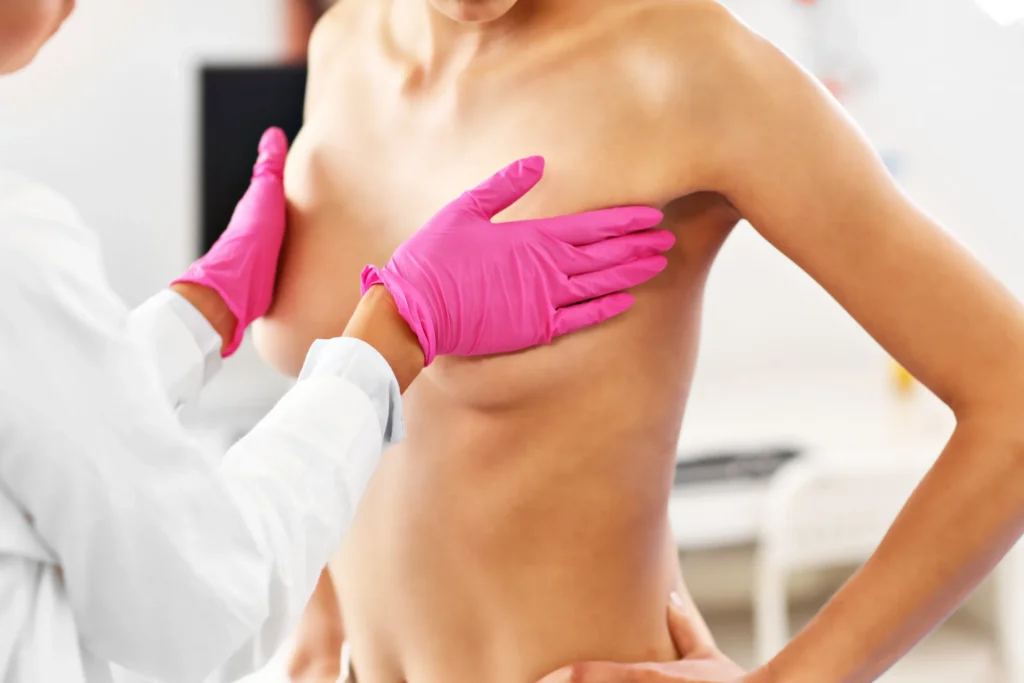 Woman receiving a breast exam from a medical professional