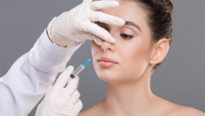 Practitioner injecting filler into the side of a model’s nose