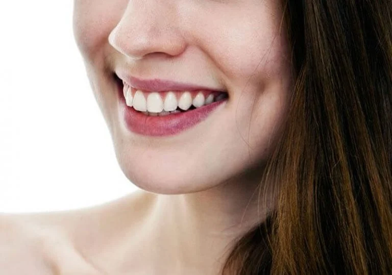 Close-up of a smiling woman's cheek and mouth